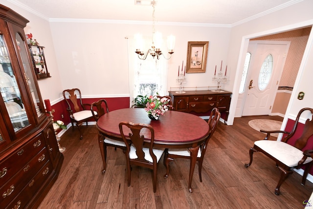 dining area featuring dark wood-type flooring, baseboards, crown molding, and a notable chandelier