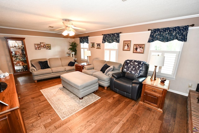 living area featuring a ceiling fan, ornamental molding, and wood finished floors
