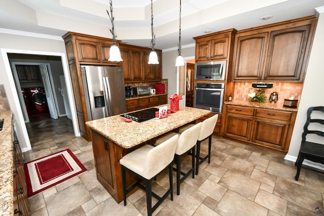 kitchen with stone tile floors, stainless steel appliances, a kitchen island, and tasteful backsplash