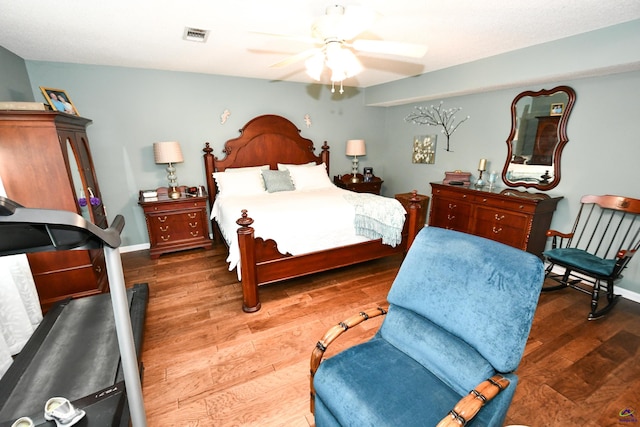 bedroom featuring visible vents, baseboards, ceiling fan, and wood finished floors