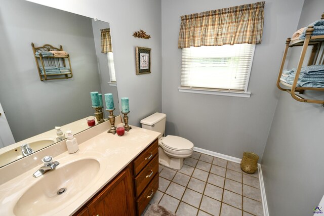 bathroom featuring vanity, tile patterned flooring, baseboards, and toilet
