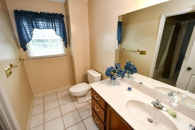 bathroom featuring vanity, baseboards, tile patterned floors, and toilet
