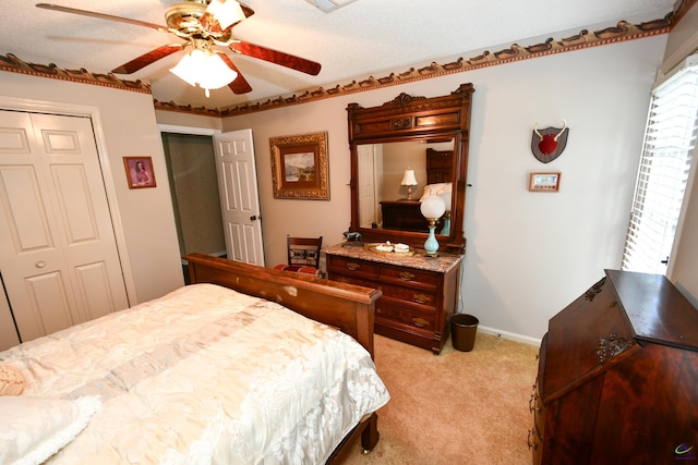 bedroom featuring baseboards, ceiling fan, a closet, and light colored carpet