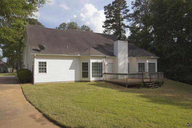 back of property featuring a lawn, a deck, and a chimney