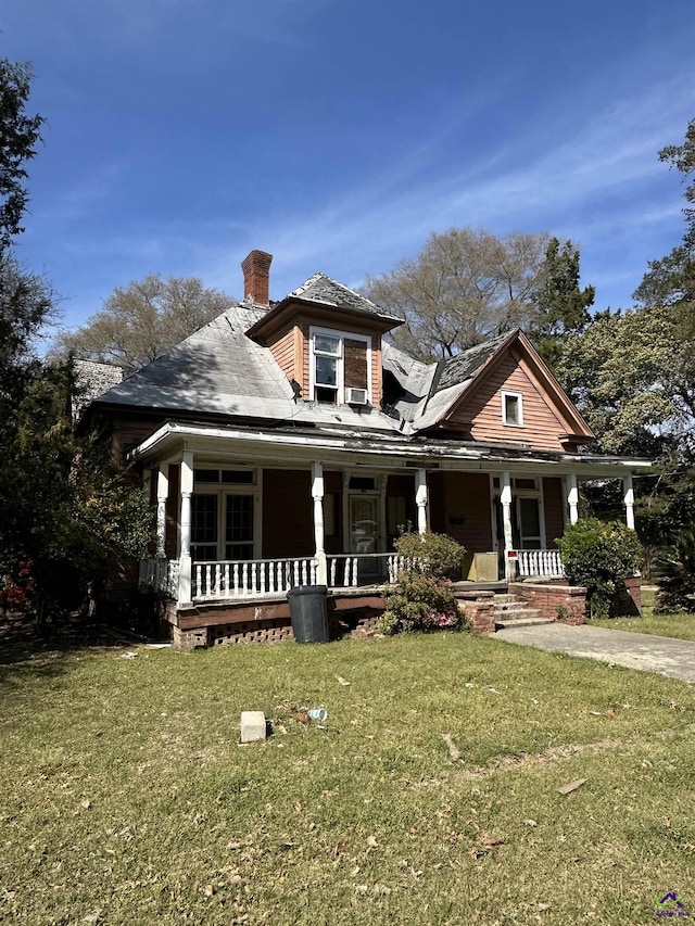view of front of property featuring a porch, a front yard, and a chimney