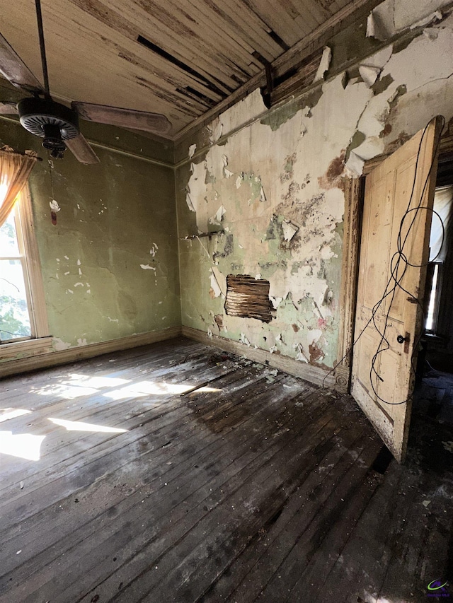 interior space with a ceiling fan, baseboards, and hardwood / wood-style flooring