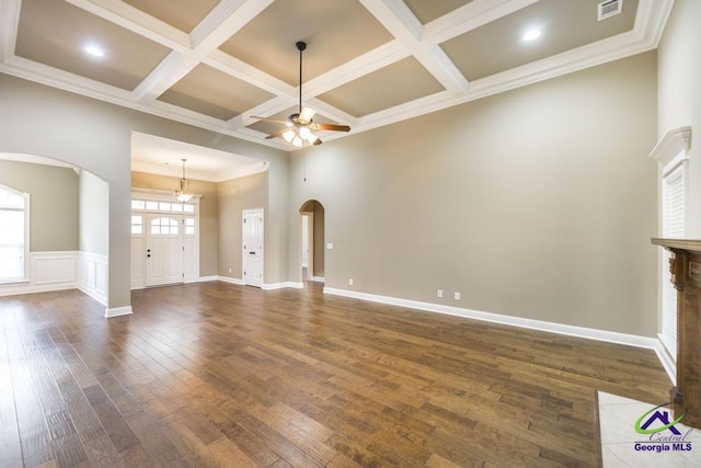 unfurnished living room featuring beam ceiling, arched walkways, dark wood finished floors, a ceiling fan, and coffered ceiling