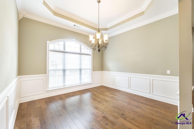 spare room with wainscoting, visible vents, a tray ceiling, and a notable chandelier