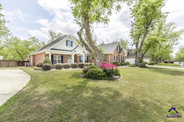 view of front facade featuring brick siding, fence, and a front lawn