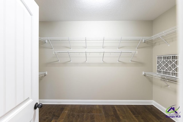 walk in closet with wood finished floors