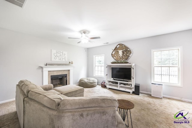 carpeted living room featuring visible vents, a ceiling fan, baseboards, and a tile fireplace
