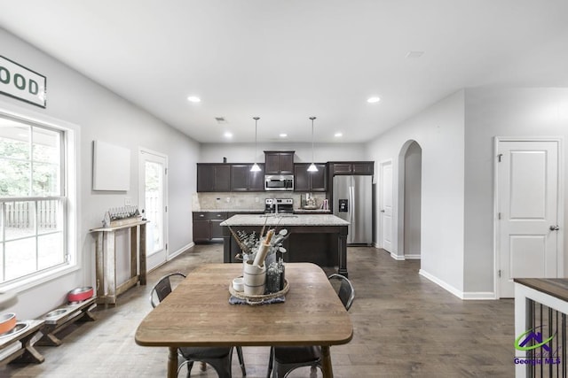 dining space with baseboards, arched walkways, dark wood-style flooring, and recessed lighting
