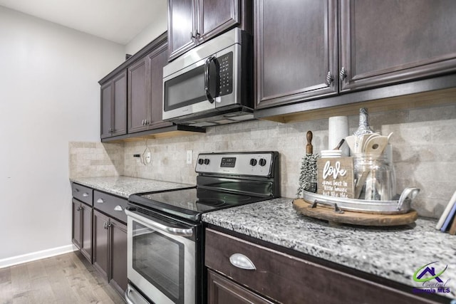 kitchen with tasteful backsplash, light stone countertops, dark brown cabinets, light wood finished floors, and stainless steel appliances