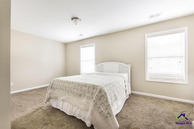 bedroom with baseboards, visible vents, and carpet