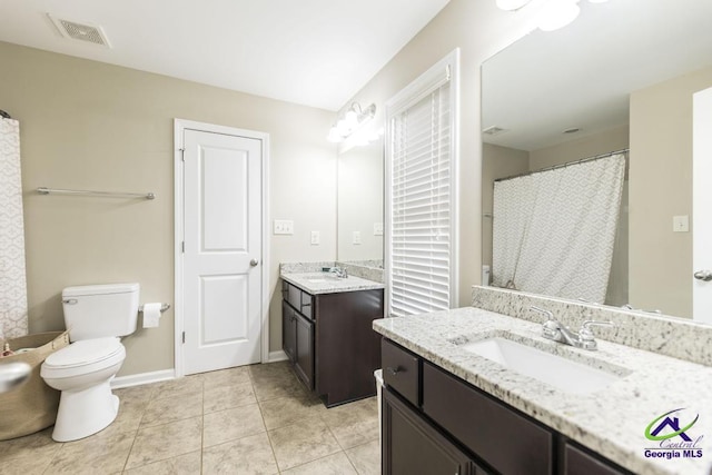full bath featuring visible vents, a sink, two vanities, and toilet