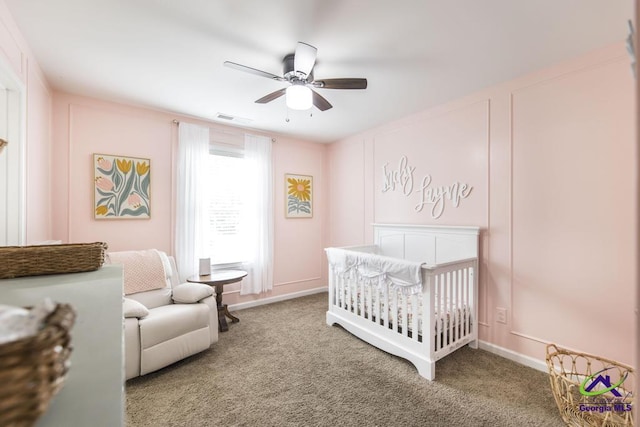 bedroom featuring a crib, a ceiling fan, carpet floors, and visible vents