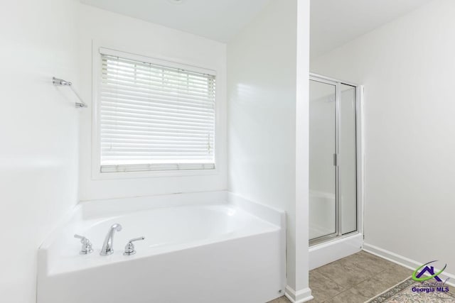full bath featuring tile patterned flooring, a garden tub, and a stall shower