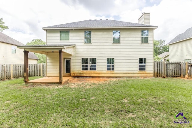 rear view of house with a patio, a fenced backyard, roof with shingles, a chimney, and a lawn