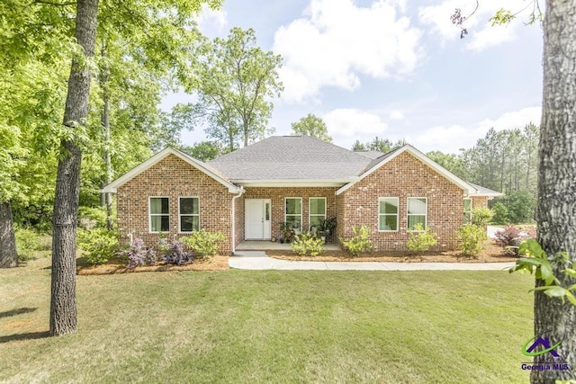 single story home with brick siding, a front lawn, and roof with shingles