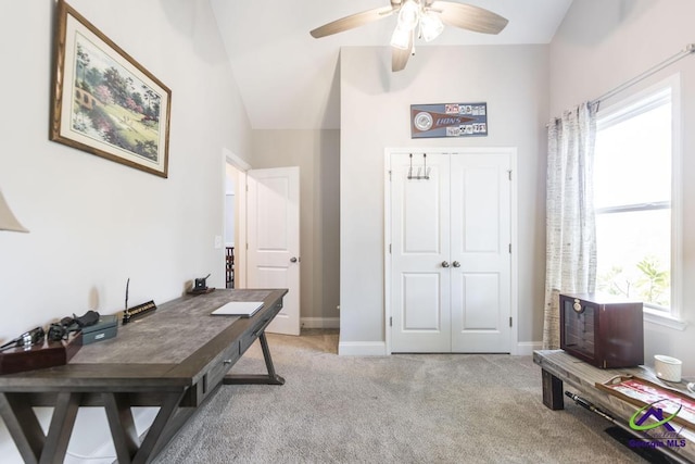office area with baseboards, ceiling fan, vaulted ceiling, and light carpet
