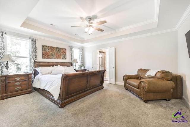 bedroom with a raised ceiling, multiple windows, light colored carpet, and visible vents