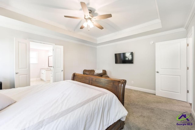 carpeted bedroom featuring ornamental molding, baseboards, a raised ceiling, a ceiling fan, and ensuite bath