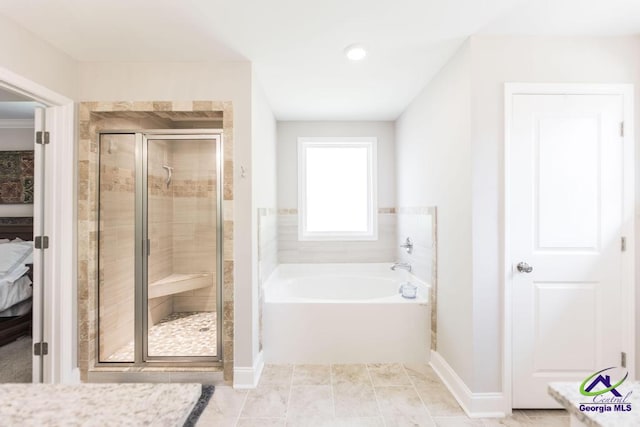 bathroom with a stall shower, a bath, and ensuite bath
