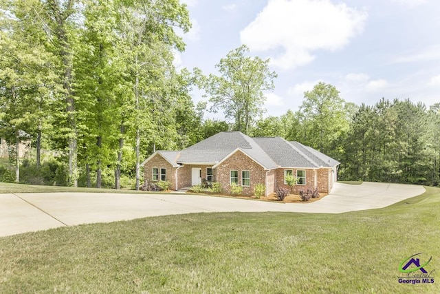 ranch-style house featuring a shingled roof, concrete driveway, a front lawn, and brick siding