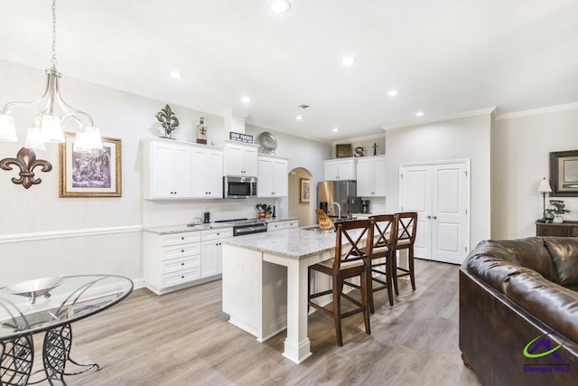 kitchen featuring crown molding, stainless steel appliances, a sink, and a kitchen bar