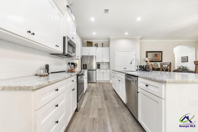 kitchen with visible vents, ornamental molding, white cabinets, a sink, and appliances with stainless steel finishes