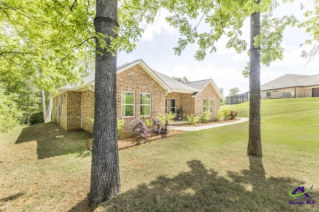 ranch-style house featuring brick siding and a front lawn