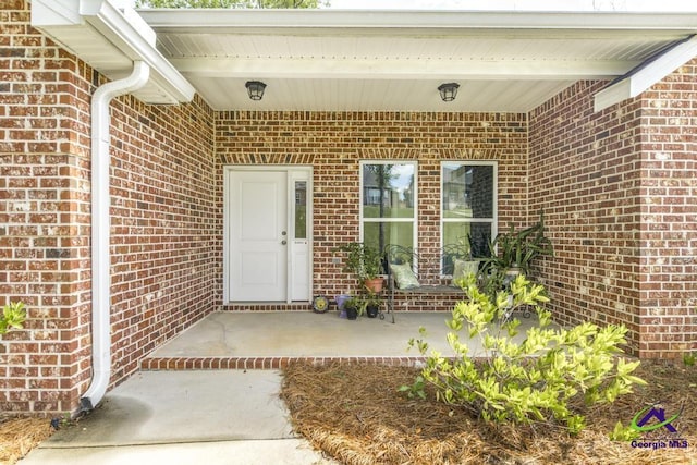 view of exterior entry with brick siding