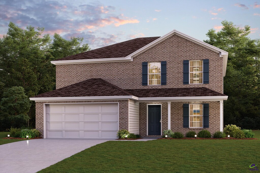 traditional-style house featuring a yard, driveway, and brick siding