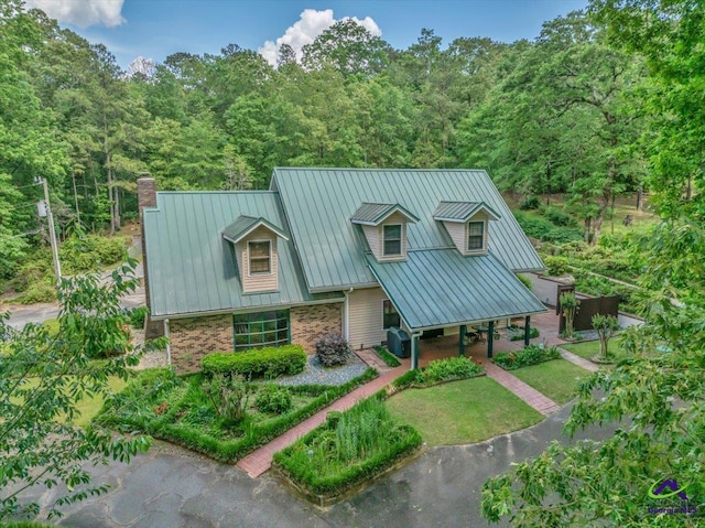 124 Joy Dr, Warner Robins, GA 31088 - view of front facade featuring brick siding, a chimney, metal roof, and a wooded view