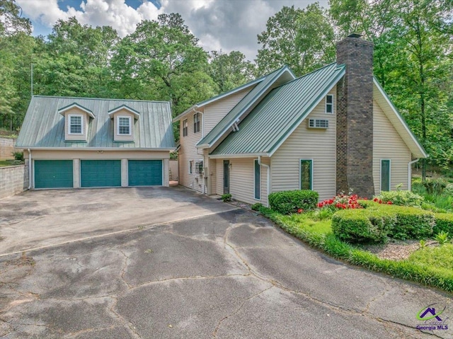 124 Joy Dr, Warner Robins, GA 31088 - view of front of property featuring a detached garage, a chimney, and metal roof