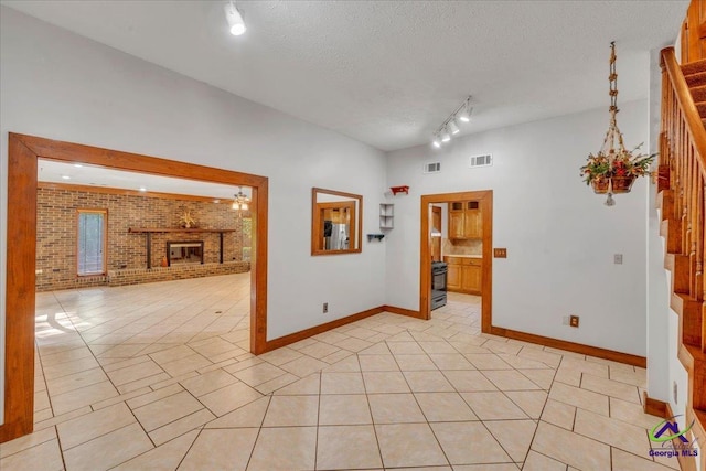 124 Joy Dr, Warner Robins, GA 31088 - spare room featuring brick wall, stairs, baseboards, light tile patterned floors, and visible vents