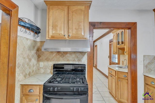124 Joy Dr, Warner Robins, GA 31088 - kitchen with black range with gas cooktop, light tile patterned floors, light countertops, ventilation hood, and a sink