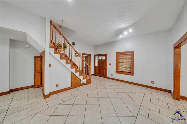 124 Joy Dr, Warner Robins, GA 31088 - entrance foyer with light tile patterned flooring, baseboards, stairway, and a textured ceiling