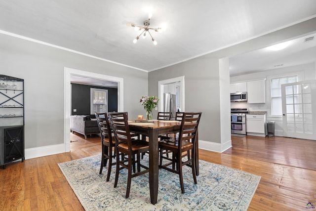 dining space with light wood-style floors, baseboards, and a chandelier