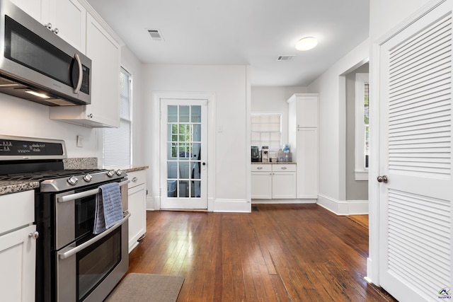 kitchen with stone counters, white cabinets, stainless steel appliances, and dark wood-style flooring