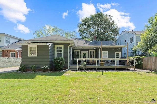 view of front of home featuring fence, a wooden deck, and a front yard
