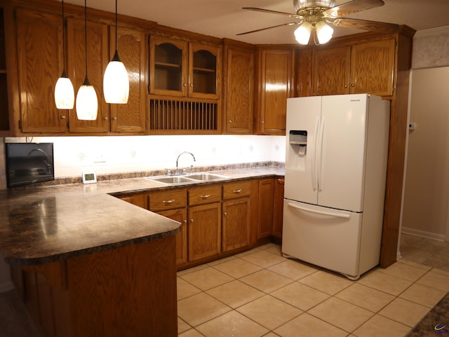 kitchen with a sink, white refrigerator with ice dispenser, brown cabinets, a ceiling fan, and light tile patterned floors
