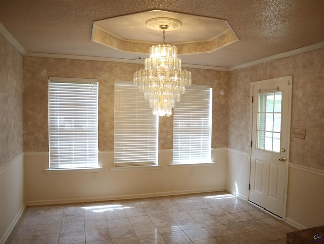 unfurnished dining area featuring a tray ceiling, a textured ceiling, and a notable chandelier