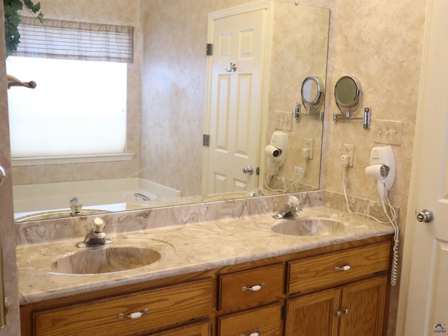 bathroom featuring double vanity, a sink, and a tub to relax in