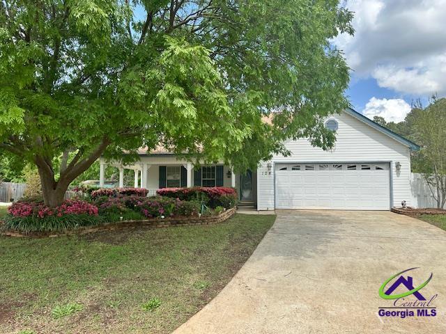 obstructed view of property with a garage, driveway, and a front yard