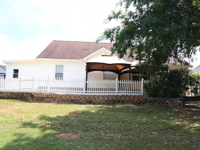 back of house featuring a yard, a gazebo, fence, and a shingled roof