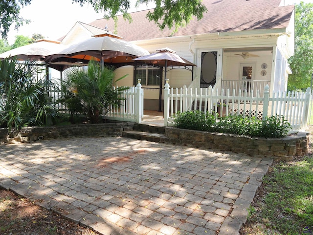 view of front of house with a gazebo, a shingled roof, and a fenced front yard