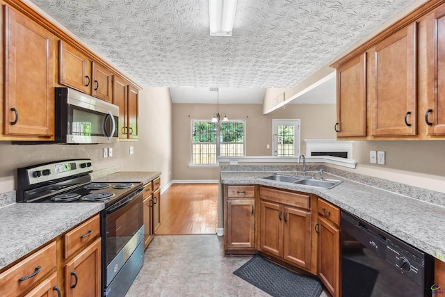 203 York Ln, Macon, GA 31220 - kitchen with brown cabinets, a sink, light countertops, stainless steel appliances, and a peninsula