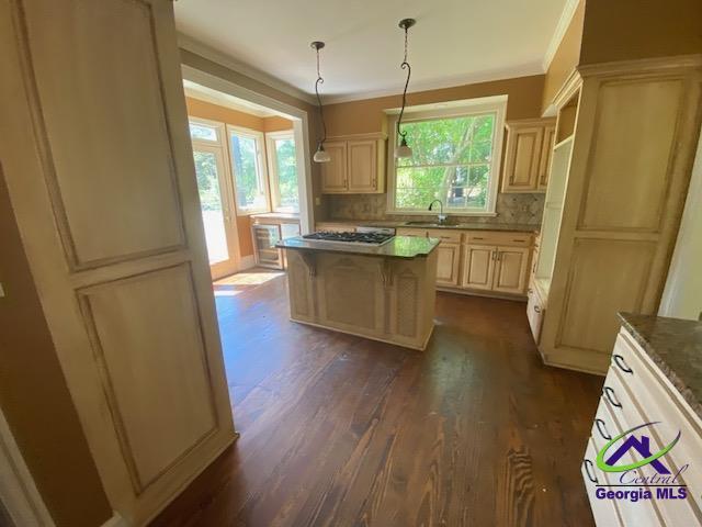 1218 Nottingham Dr, Macon, GA 31210 - kitchen featuring gas cooktop, a center island, tasteful backsplash, a sink, and dark wood-style floors