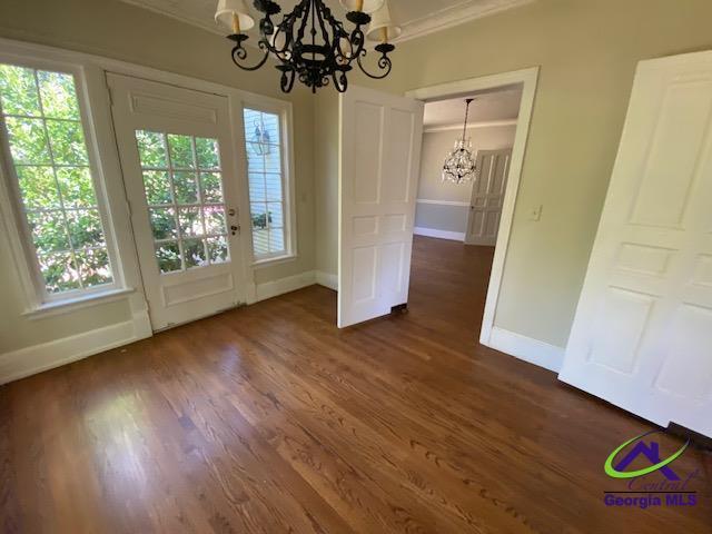 1218 Nottingham Dr, Macon, GA 31210 - unfurnished dining area with baseboards, ornamental molding, and a notable chandelier